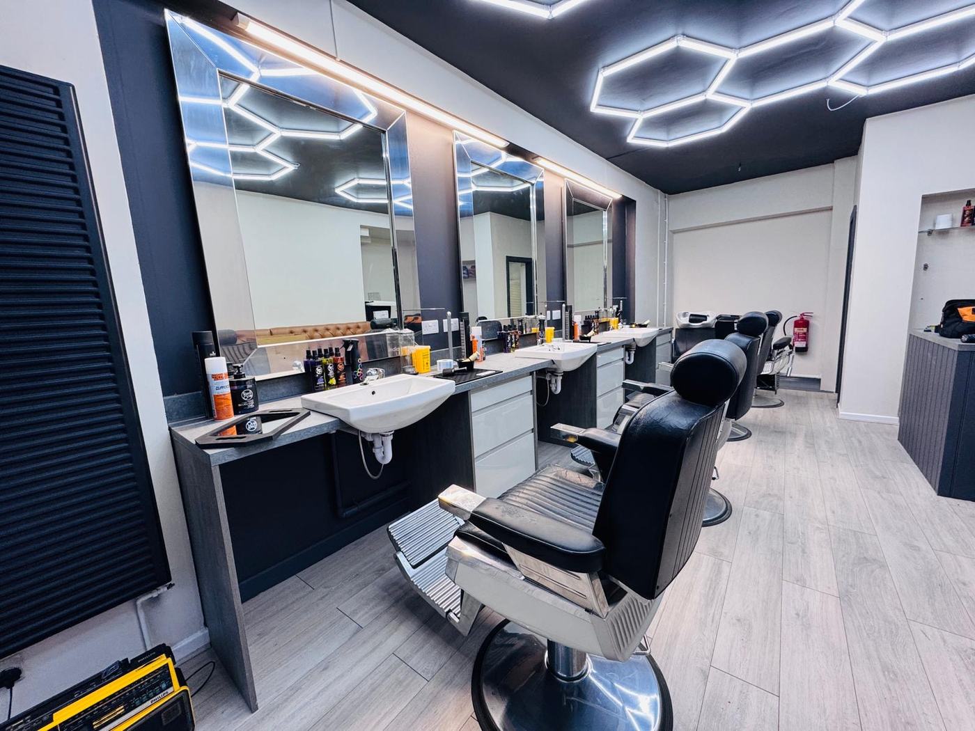 The shop floor at Danny's Barber, lit by hexagon ceiling lights